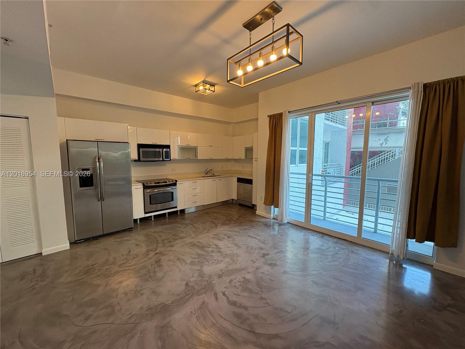 A kitchen with white cabinets, stainless steel appliances, and a polished concrete floor — 133 NE 2nd Ave # 210, Miami FL 33132, MIAMI, FL