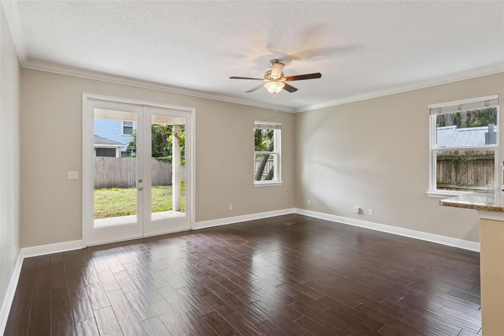A backyard view of a two-story house with a covered patio and wooden privacy fence — 2544 MAYER STREET, ORLANDO, FL