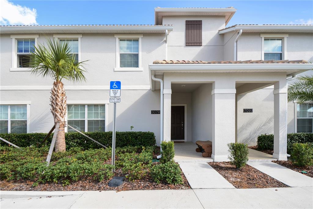 A two-story residential building exterior features two front entrances with a palm tree and landscaping — 3079 TOM SAWYER DRIVE, KISSIMMEE, FL