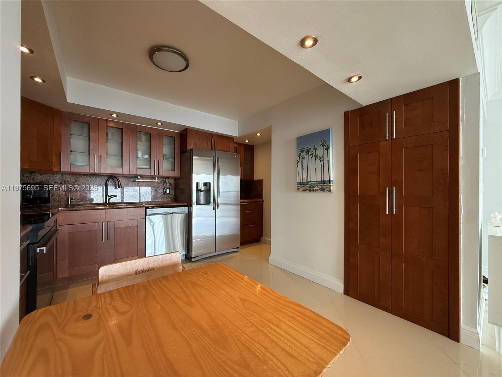 A kitchen features wood cabinets, stainless steel appliances, and a light-colored tile floor — 2101 S Ocean Dr # 1201, Hollywood FL 33019, HOLLYWOOD, FL