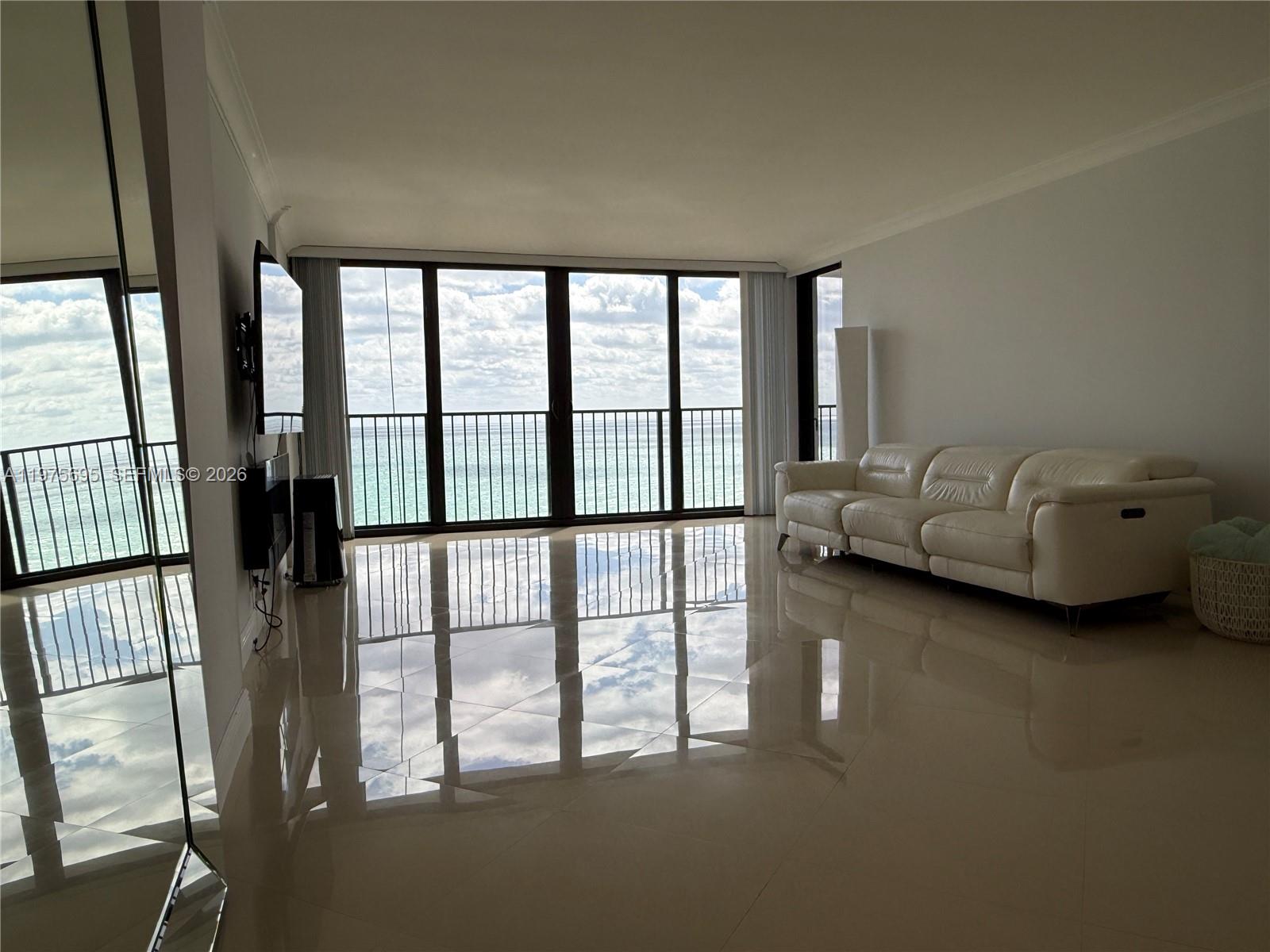 A living room with white tile floors, a white leather sofa, and floor-to-ceiling ocean views — 2101 S Ocean Dr # 1201, Hollywood FL 33019, HOLLYWOOD, FL