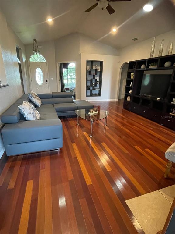 A living room features a gray sectional sofa, a glass coffee table, and hardwood floors — 4005 CHELSEA LANE, LAKELAND, FL