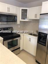 A kitchen featuring white cabinets, stainless steel appliances, and a light-colored countertop — 1575 NW 127th St, North Miami FL 33167, NORTH MIAMI, FL