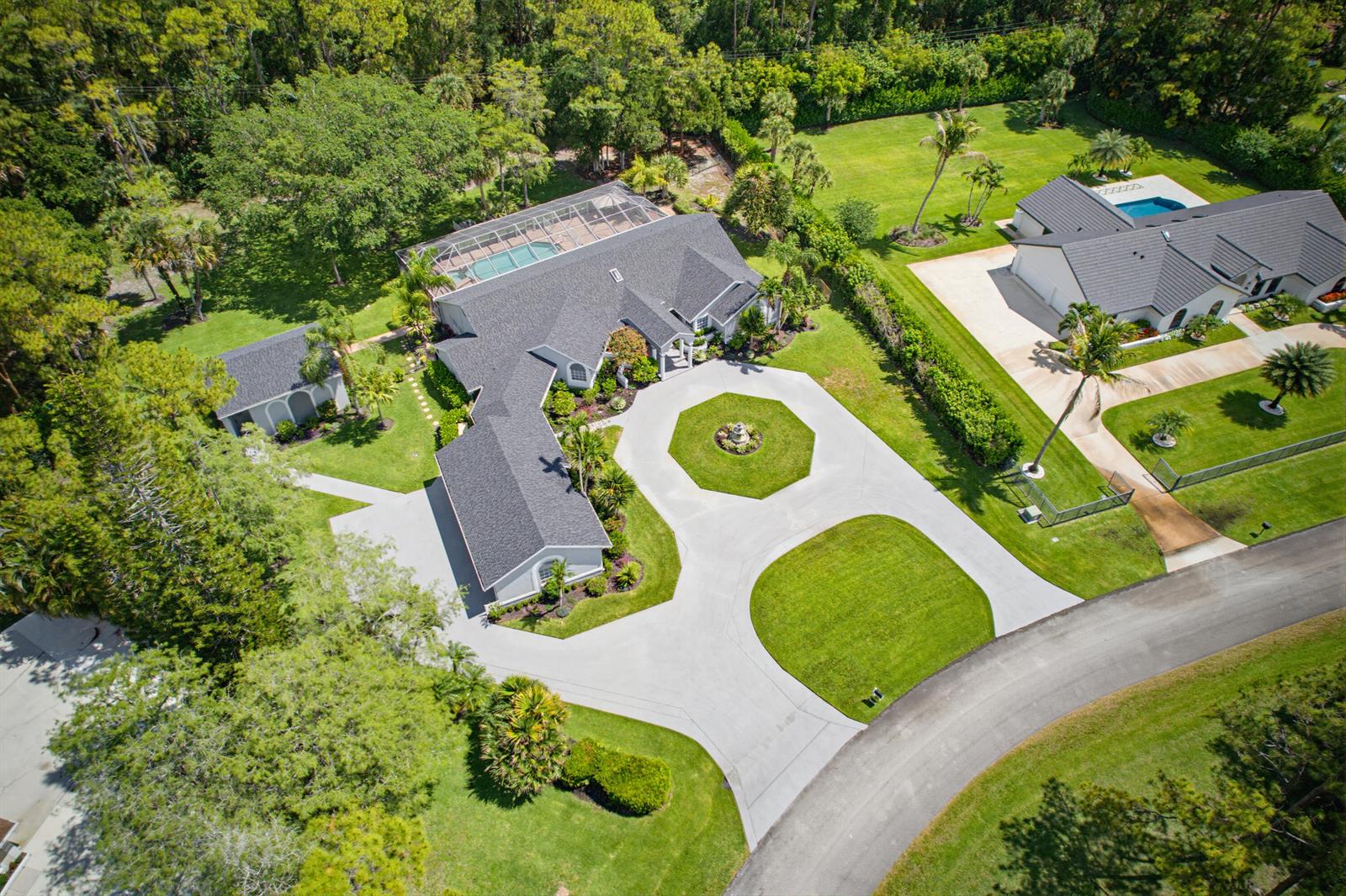 An aerial view shows a house with a large circular driveway, pool, and surrounding landscaping — 14708 Stirrup Lane, Wellington FL 33414, WELLINGTON, FL