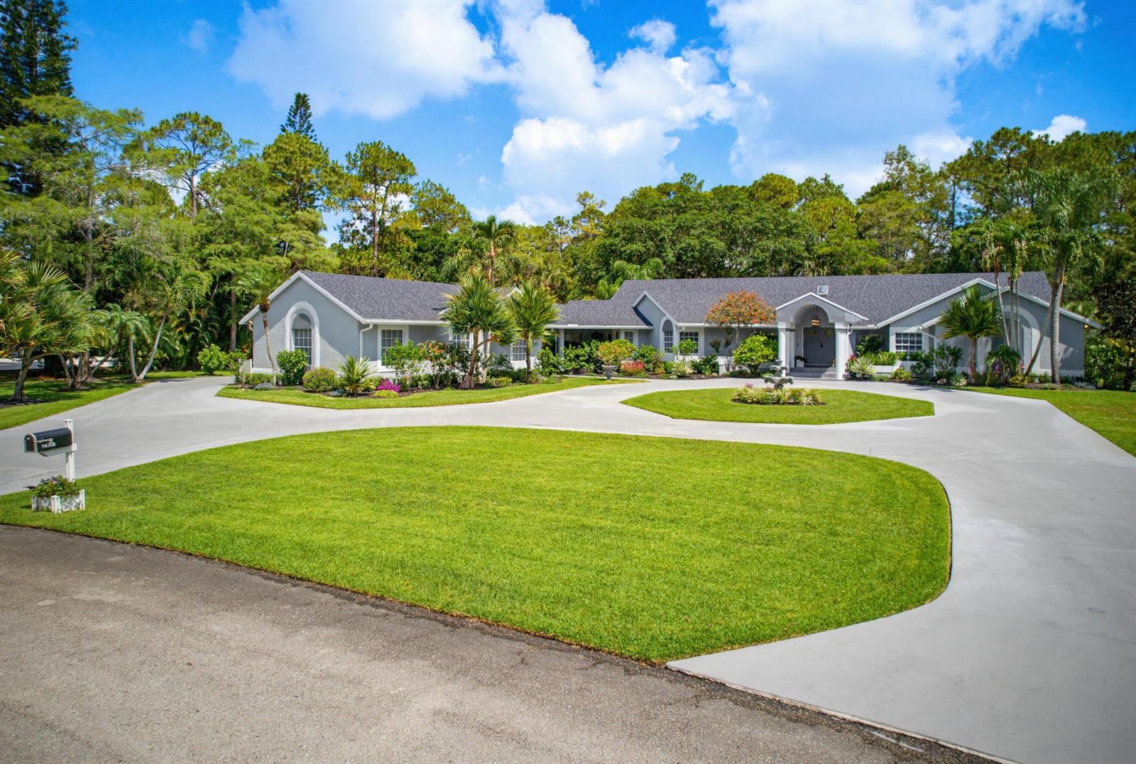 A single-story house with a circular driveway and a large front lawn — 14708 Stirrup Lane, Wellington FL 33414, WELLINGTON, FL