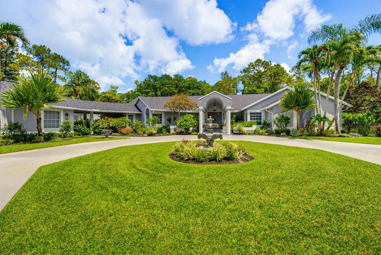 A single-story house with a circular driveway and a central fountain in the front yard — 14708 Stirrup Lane, Wellington FL 33414, WELLINGTON, FL