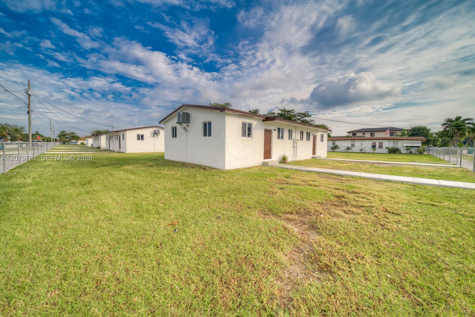 A white, single-story residential building with a brown door sits on a grassy lot — 17727 SW 103rd Ave # 17727, Miami FL 33157, MIAMI, FL