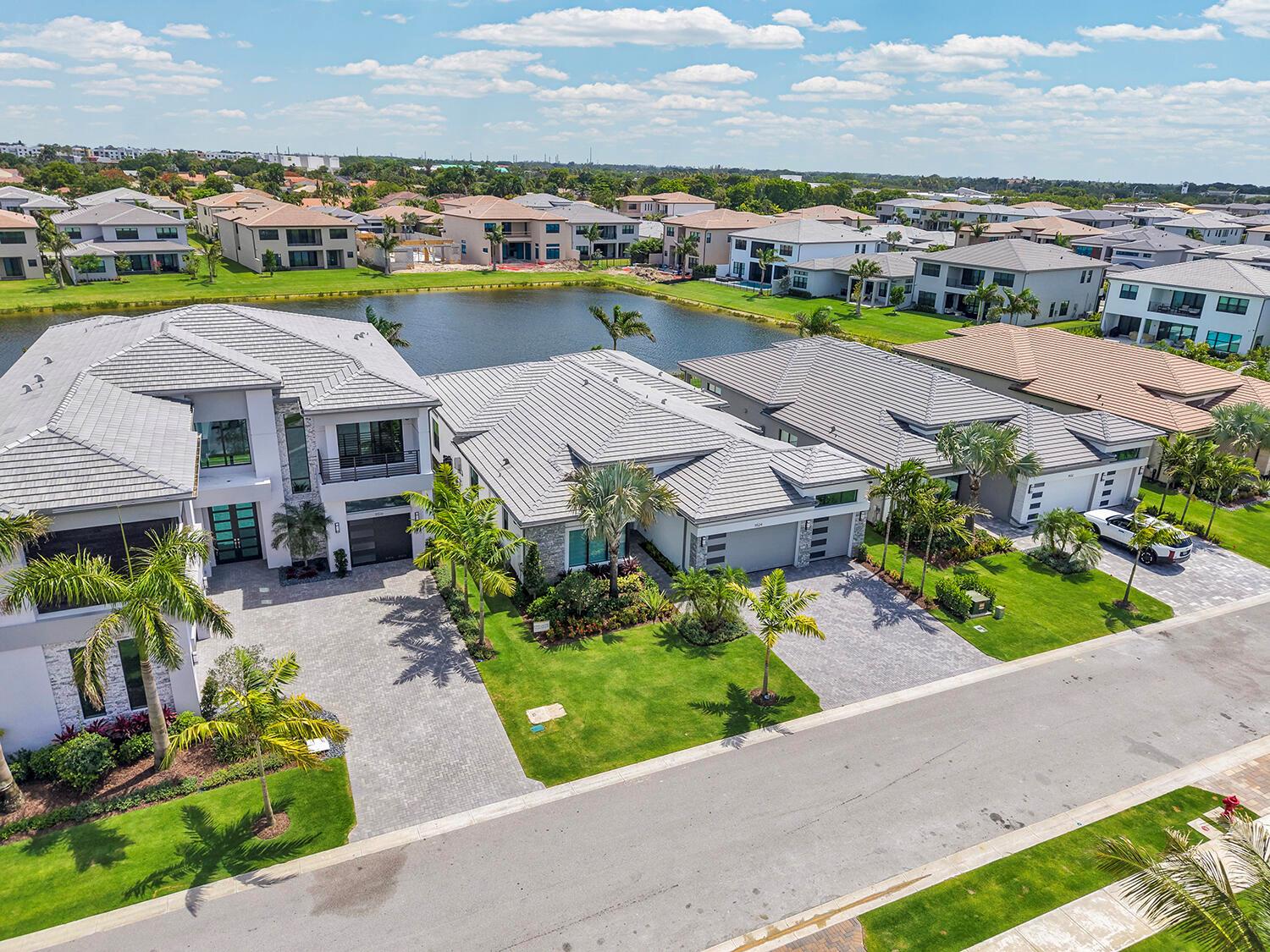 An aerial view shows modern suburban houses with gray tile roofs bordering a small lake — 9524 Riverside Park Drive, Boca Raton FL 33434, BOCA RATON, FL