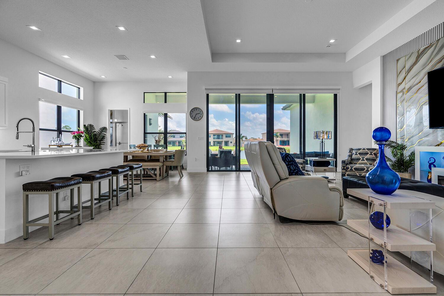 An open-concept living area features a kitchen with bar seating and a view of the outdoors — 9524 Riverside Park Drive, Boca Raton FL 33434, BOCA RATON, FL
