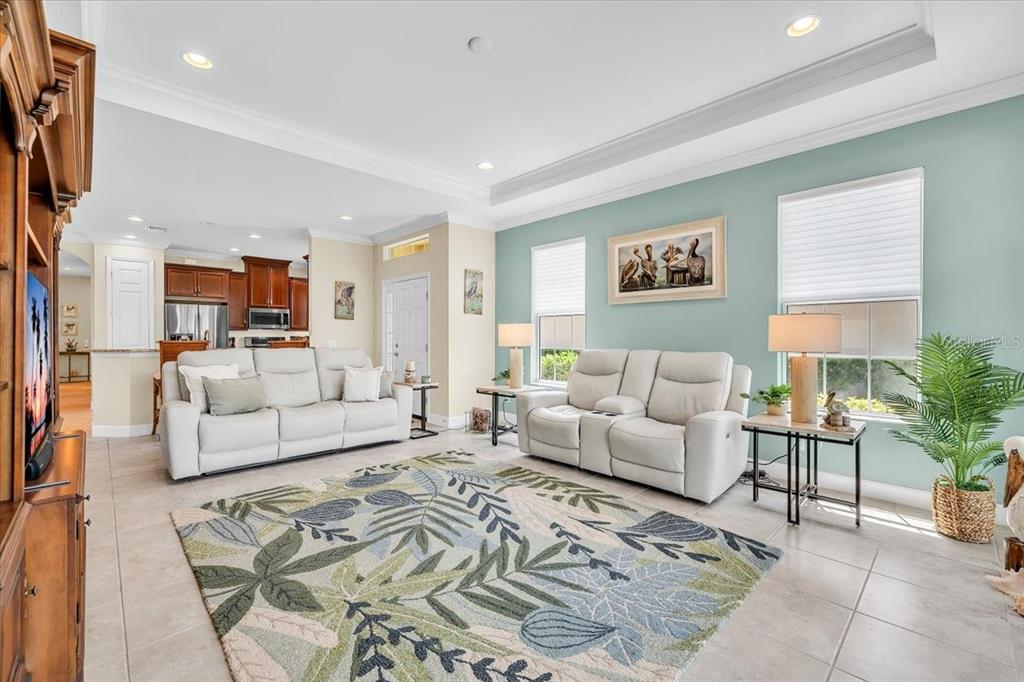 A living room features light-colored sofas, a patterned area rug, and a light blue wall — 2615 VAREO COURT, CAPE CORAL, FL