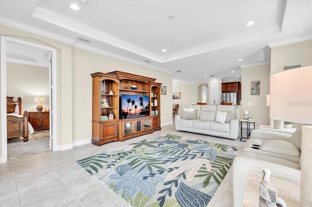 A living room features a large wooden entertainment center, light-colored sofa, and a patterned rug — 2615 VAREO COURT, CAPE CORAL, FL