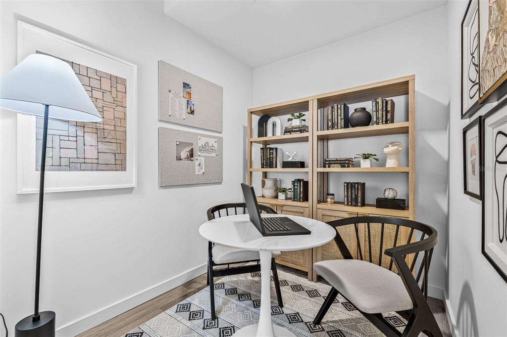 A home office features a round table, two chairs, a bookshelf, and wall art — 221 MAIN STREET N UNIT B4-1115, ST PETERSBURG, FL