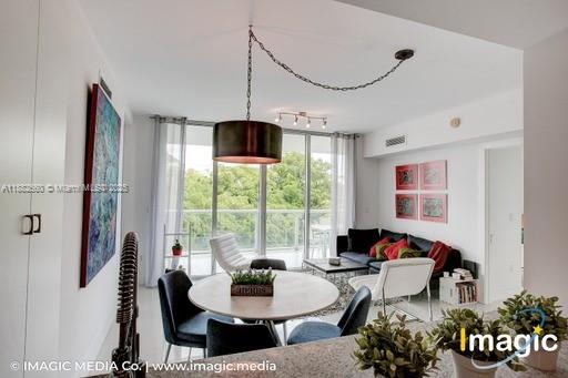 A dining area with a round table and pendant light opens into a living room — 720 NE 62nd St # 402, Miami FL 33138, MIAMI, FL