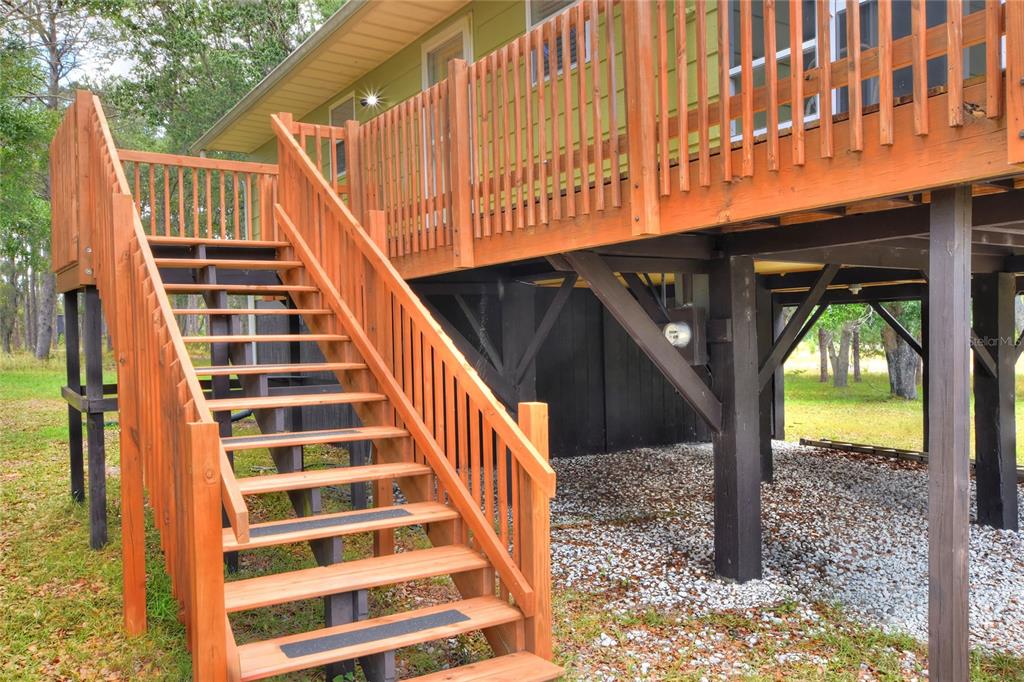 A wooden staircase leads up to a raised deck attached to a green house — 1885 PFUNDSTEIN ROAD, LAKE WALES, FL
