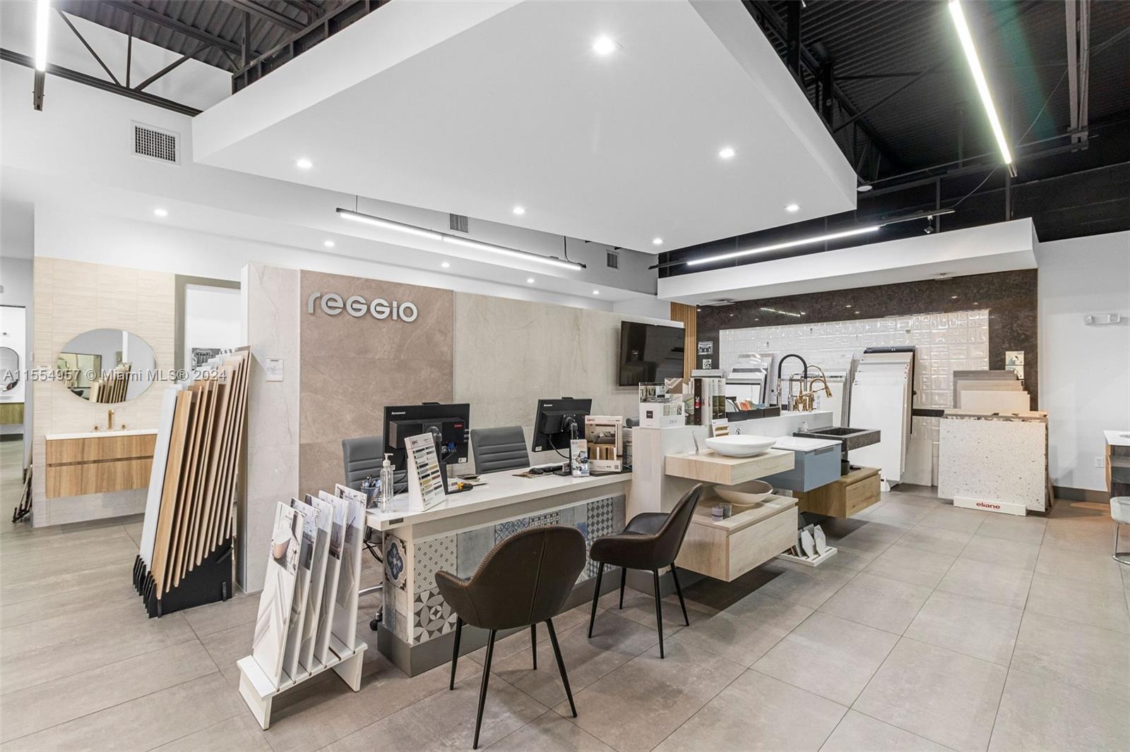 A modern showroom features a reception desk, tile displays, and bathroom vanity samples — Bath Vanities/Accessories and Flooring, Doral FL 33122, DORAL, FL