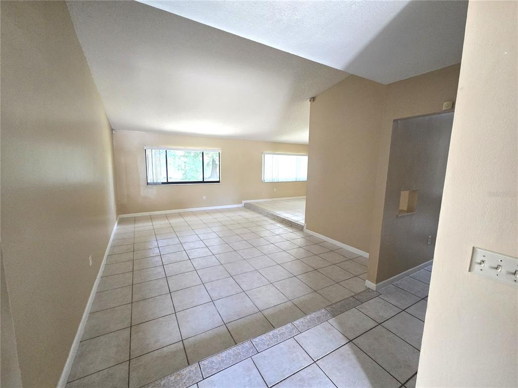 An interior view of a living area with beige walls and light-colored tile flooring — 8422 MARGARITA DRIVE, ORLANDO, FL