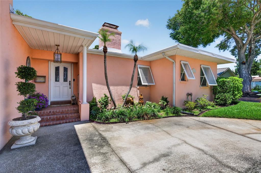 A peach-colored house features a front porch, a chimney, and two palm trees — 1209 N HALIFAX AVENUE, DAYTONA BEACH, FL