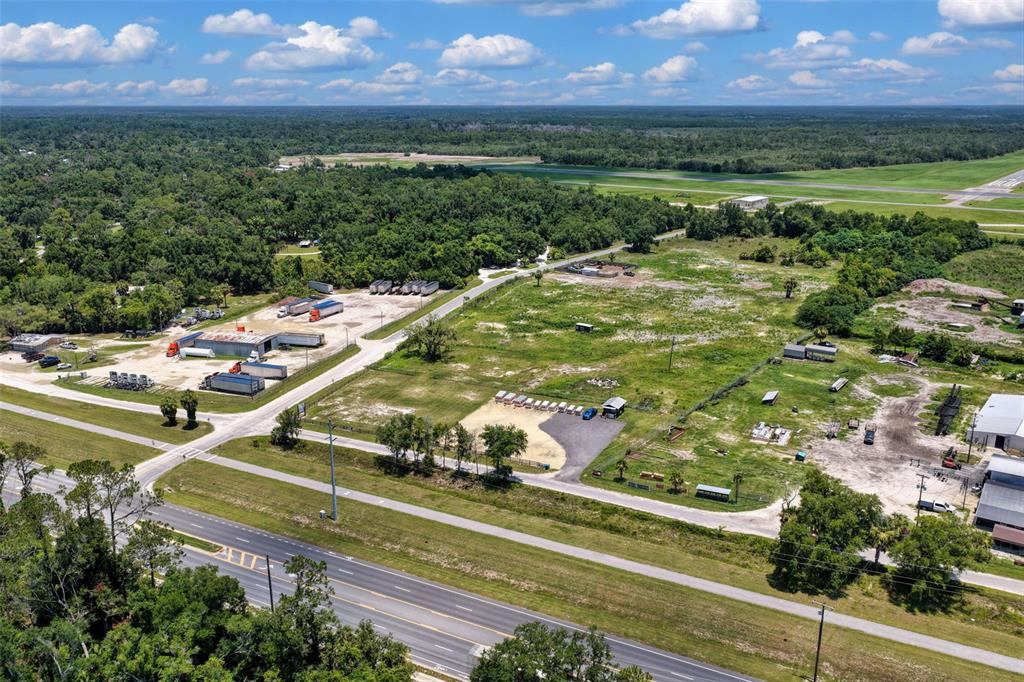 An aerial view shows a large, undeveloped plot of land next to a highway and airfield — 86 NE 170TH STREET, CROSS CITY, FL