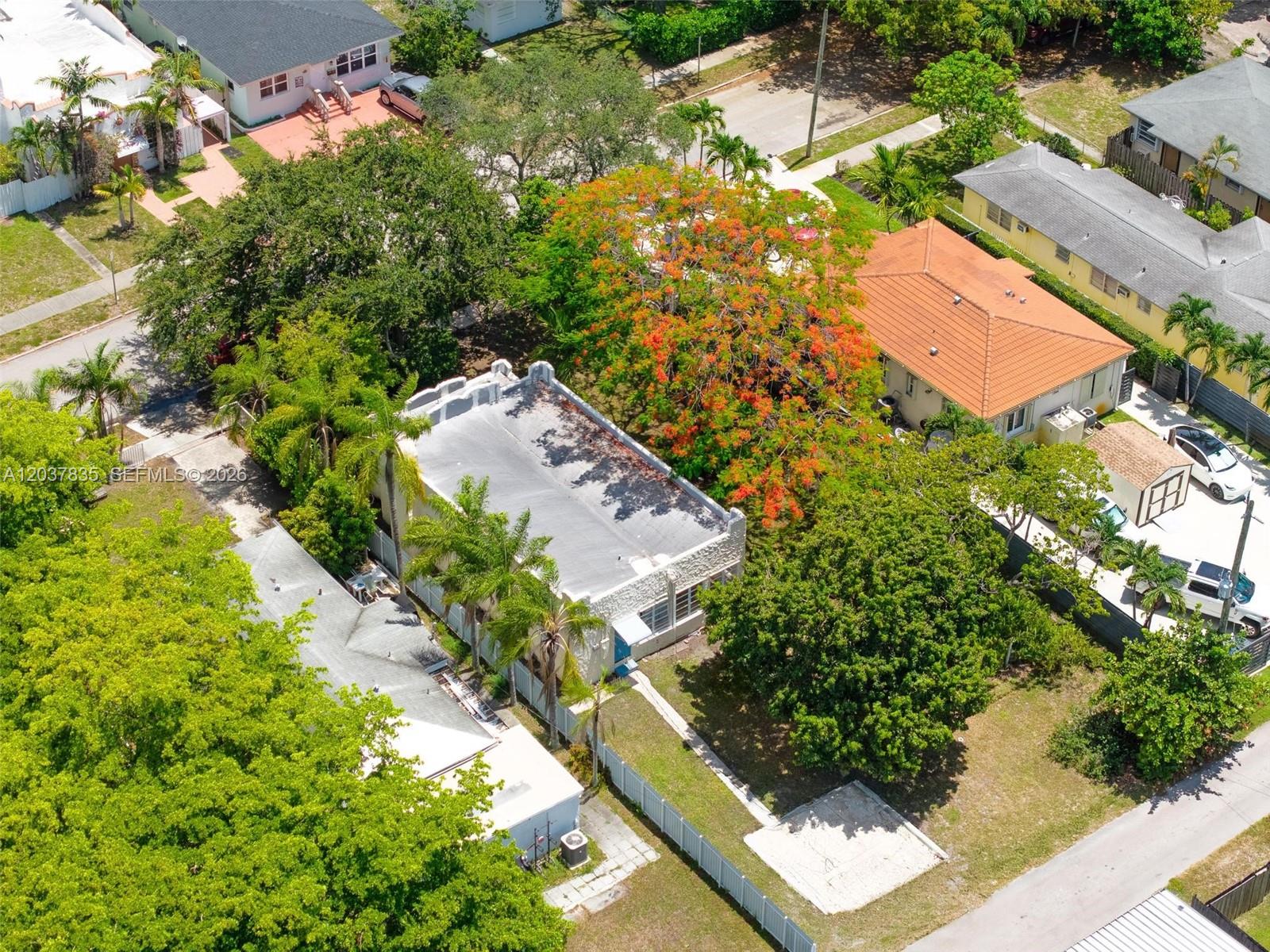 An aerial view shows a residential property with a flat-roofed building and lush landscaping — 1954 Dewey St, Hollywood FL 33020, HOLLYWOOD, FL