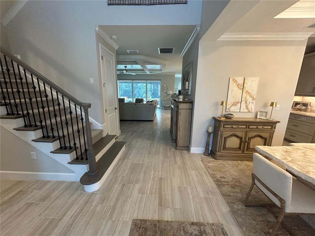 An entryway features a staircase with iron railings, tile flooring, and a view into the living area — 9217 TORRENT TRAIL, SARASOTA, FL