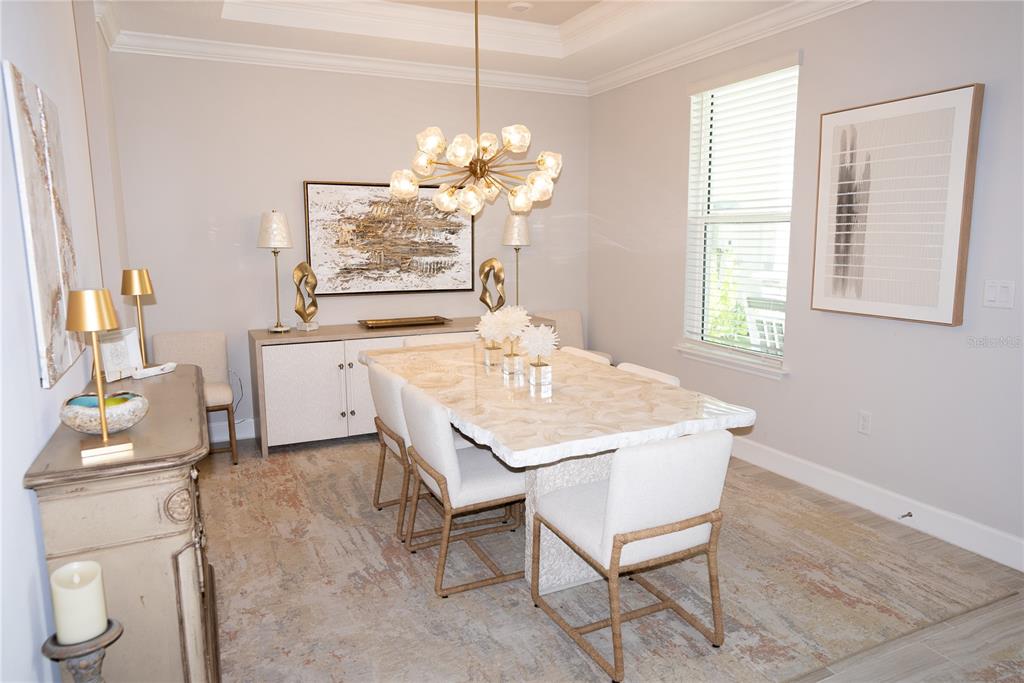 A dining room features a marble-topped table, upholstered chairs, a gold chandelier, and a sideboard — 9217 TORRENT TRAIL, SARASOTA, FL