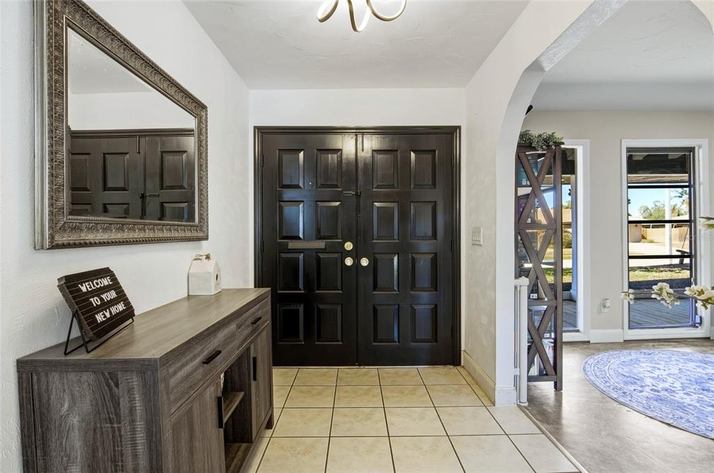 An entryway features a dark wood double door, tiled floor, and a console table — 213 DOVERWOOD ROAD, FERN PARK, FL