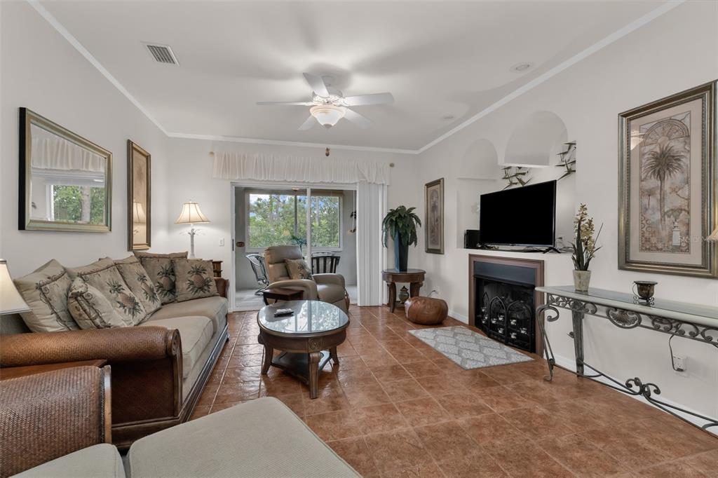 A living room features tile flooring, a fireplace with a television, and sliding glass doors — 2090 BIG PASS LANE UNIT D, PUNTA GORDA, FL