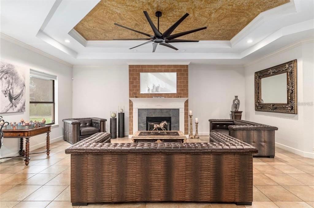A living room features a coffered ceiling, a brick fireplace, and brown leather furniture — 2901 SE 28TH LANE, OCALA, FL