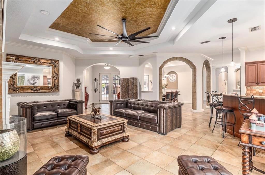 A living room with leather sofas, a coffee table, and a gold-accented tray ceiling — 2901 SE 28TH LANE, OCALA, FL