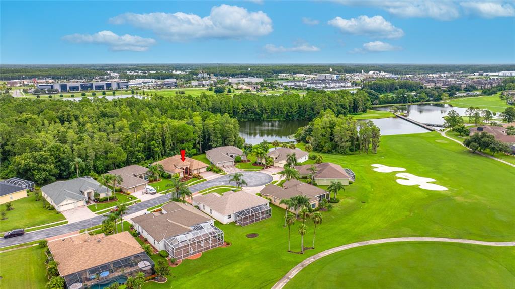 An aerial view shows several suburban houses situated along a golf course and a lake — 11421 STRATHAVEN COURT, TRINITY, FL