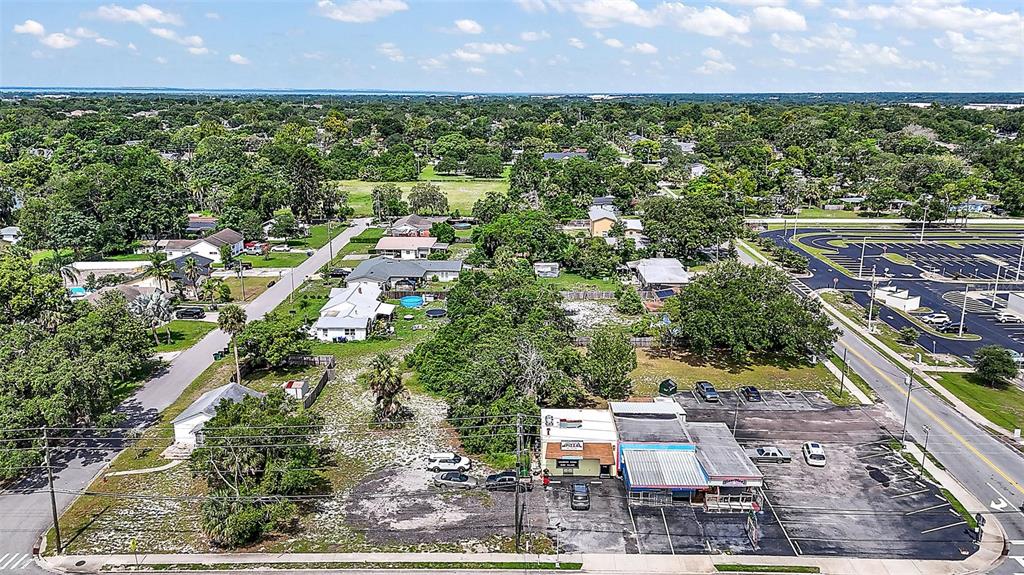 An aerial view shows a commercial building with a parking lot next to residential houses — 452 & 438 N PARK AVENUE, APOPKA, FL