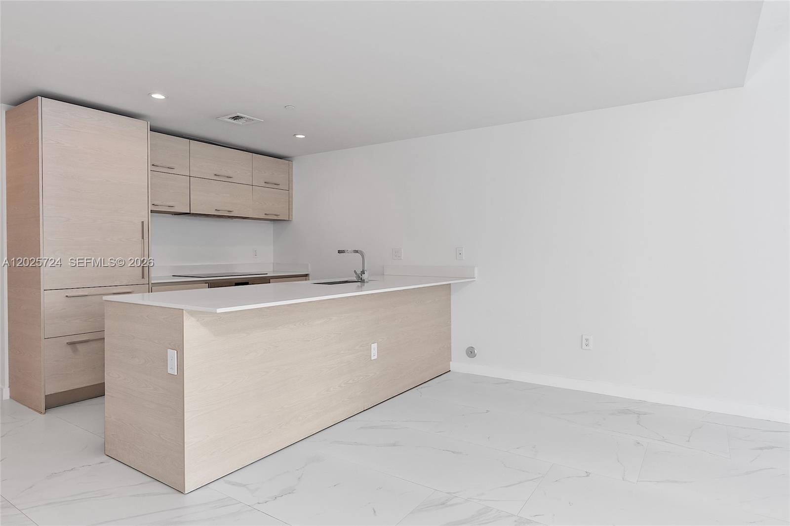 A modern kitchen features light wood cabinetry, white countertops, and white marble-patterned tile flooring — 1300 S Miami Ave # 3211, Miami FL 33130, MIAMI, FL