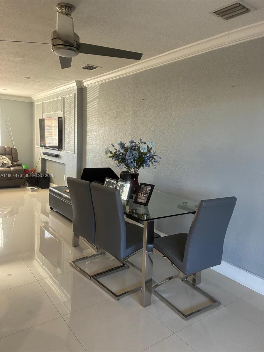 A dining area features a glass-topped table, four gray chairs, and a ceiling fan — 9425 NW 114th Ln # 3, Hialeah Gardens FL 33018, HIALEAH GARDENS, FL