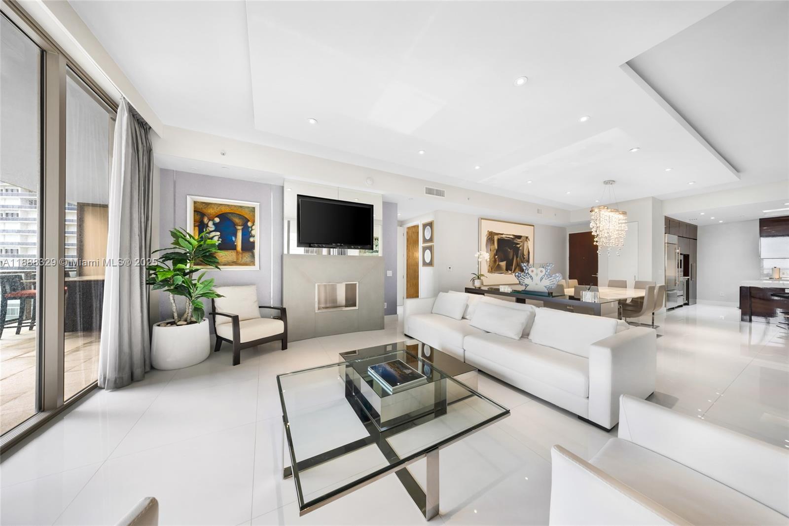 A modern living room features white tile floors, a white sofa, and a glass coffee table — 9701 Collins Avenue, Bal Harbour FL 33154, BAL HARBOUR, FL