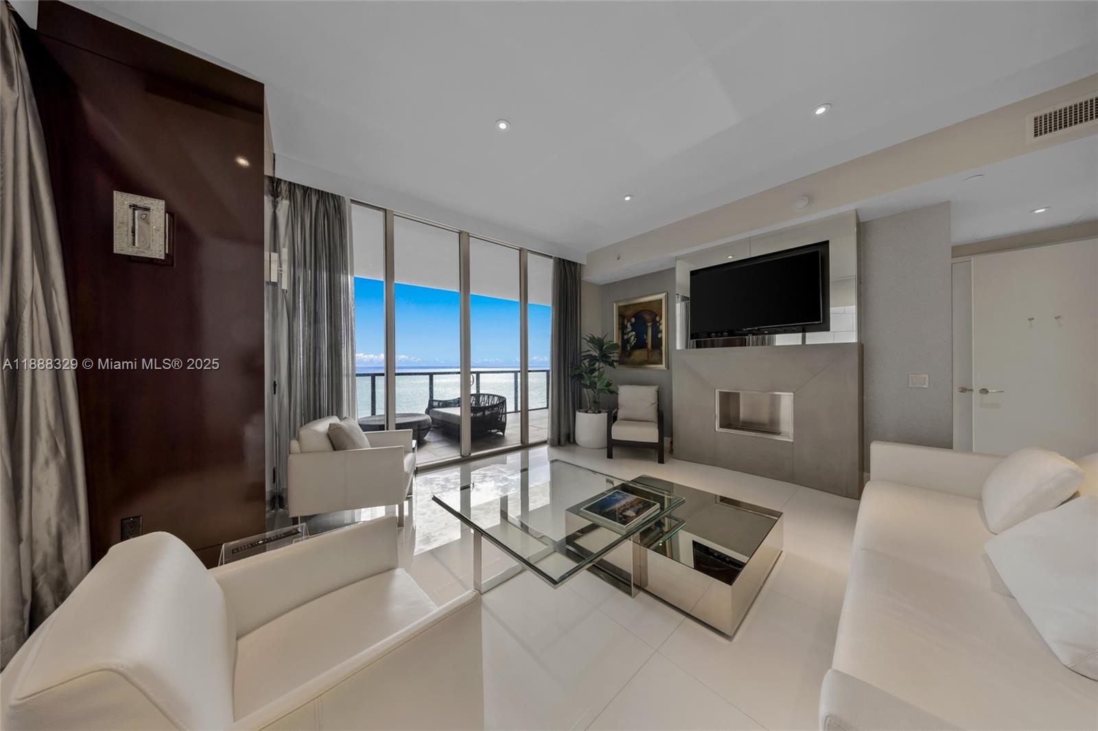 A modern living room features white furniture, a glass coffee table, and a balcony view — 9701 Collins Avenue, Bal Harbour FL 33154, BAL HARBOUR, FL