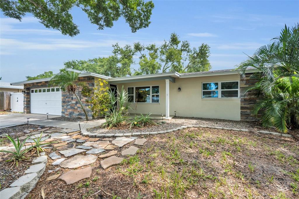 A single-story house with a stone-accented facade, a two-car garage, and a stone walkway — 13760 87TH PLACE, SEMINOLE, FL