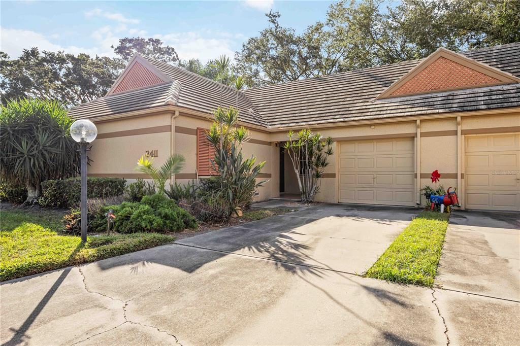 A single-story house with a beige exterior, a two-car garage, and a concrete driveway — 3411 57TH AVENUE DRIVE W UNIT 6, BRADENTON, FL
