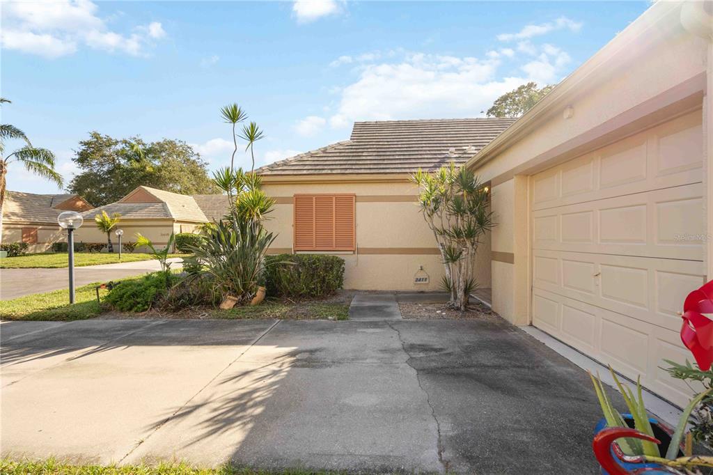 A single-story house exterior features a concrete driveway, a garage, and a small front garden — 3411 57TH AVENUE DRIVE W UNIT 6, BRADENTON, FL