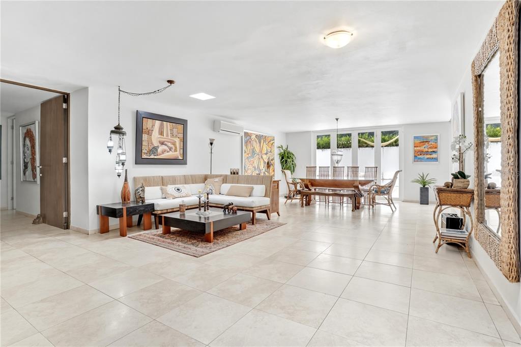 A spacious, open-concept living and dining area features white tile floors and neutral furnishings — 12-11 CALLE SEGOVIA, GUAYNABO, PR