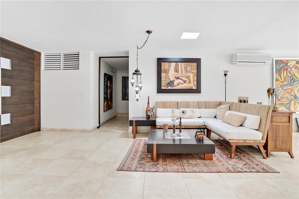 A living room with a sectional sofa, a coffee table, and artwork on white walls — 12-11 CALLE SEGOVIA, GUAYNABO, PR