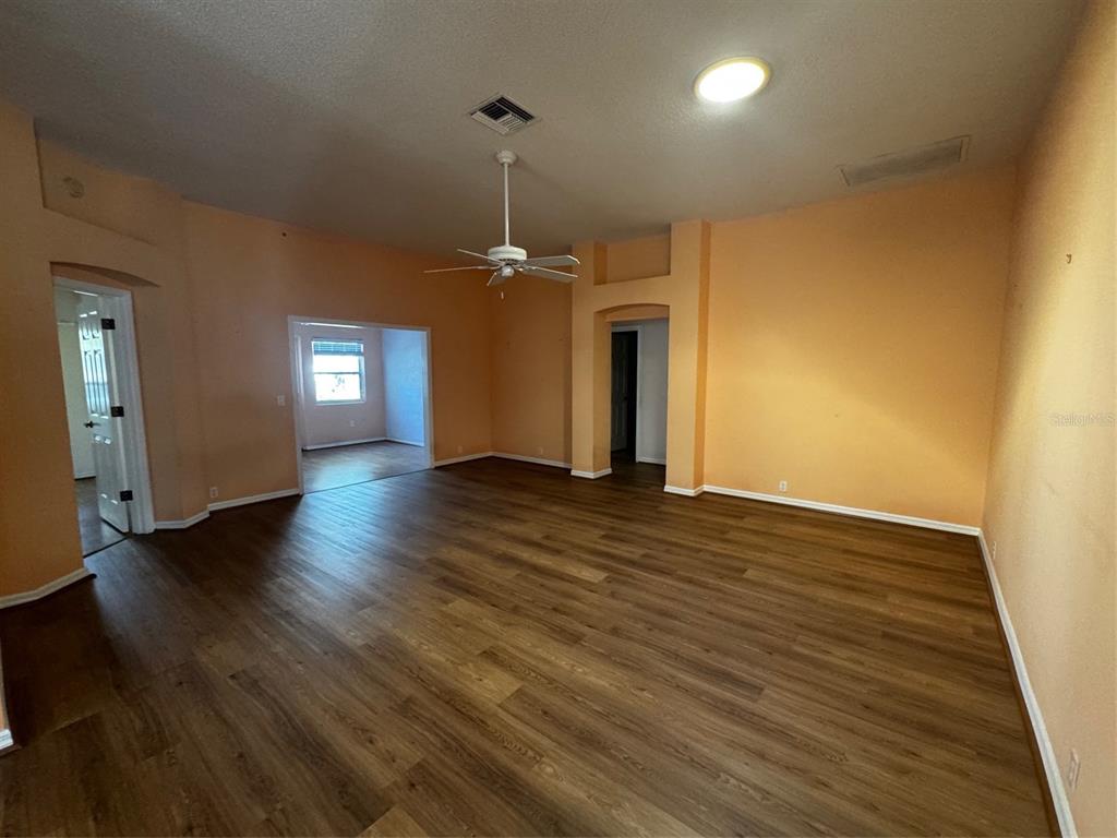 An empty room with peach-colored walls, wood-look flooring, a ceiling fan, and recessed lighting — 144 COSTA MESA DRIVE, LADY LAKE, FL
