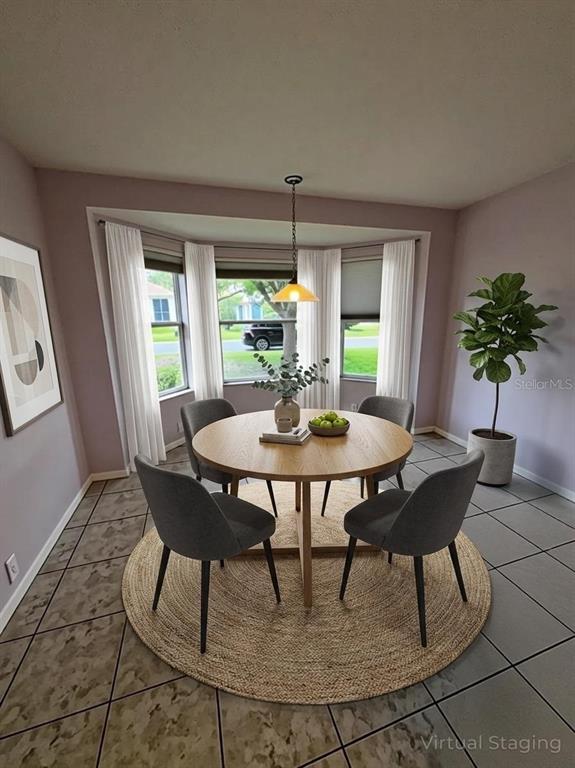 This virtual staging shows a dining area with a round table, chairs, and bay windows — 144 COSTA MESA DRIVE, LADY LAKE, FL