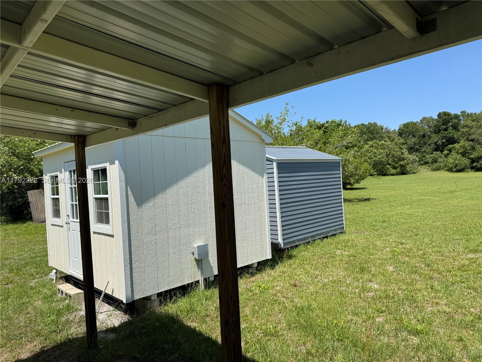 A white shed and a smaller blue shed sit on a grassy lot — 3725 SW 162 St., Archer, FL, Gainesville FL 32618, GAINESVILLE, FL
