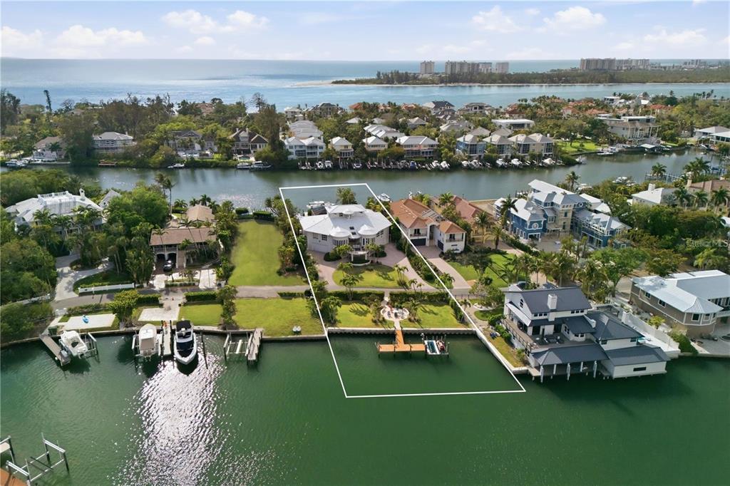 An aerial view shows a waterfront house with a private dock and pool — 4034 ROBERTS POINT ROAD, SARASOTA, FL