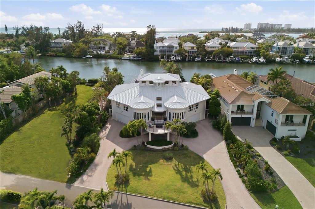 An aerial view of a large white house with a metal roof near a canal — 4034 ROBERTS POINT ROAD, SARASOTA, FL