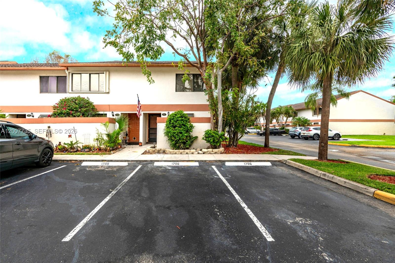 A two-story residential building features a parking lot with numbered spaces in the foreground — 7111 SW 42nd Pl, Davie FL 33314, DAVIE, FL