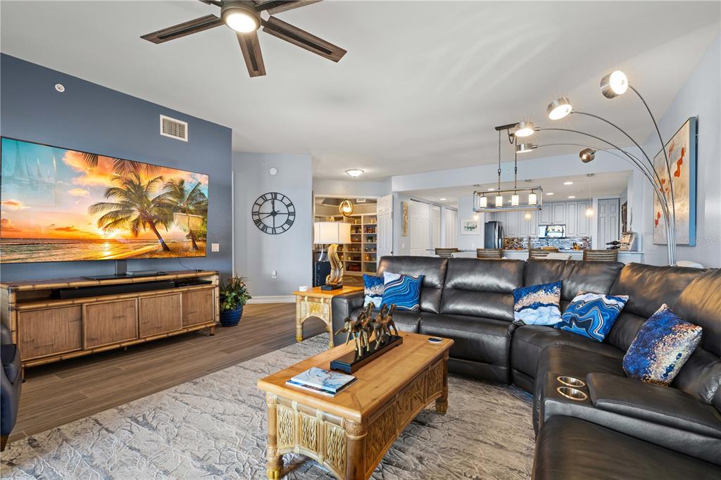 A living room features a large television, a dark leather sectional, and a wooden coffee table — 89 VIVANTE BOULEVARD UNIT 8943, PUNTA GORDA, FL
