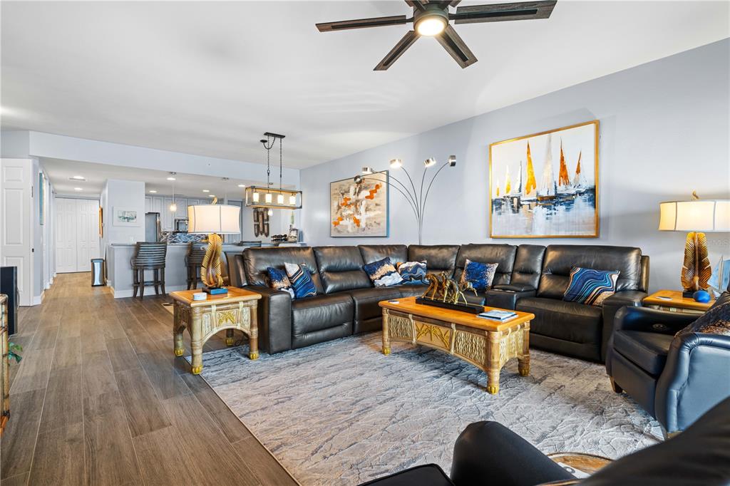 A living room features a large leather sectional, a coffee table, and a ceiling fan — 89 VIVANTE BOULEVARD UNIT 8943, PUNTA GORDA, FL