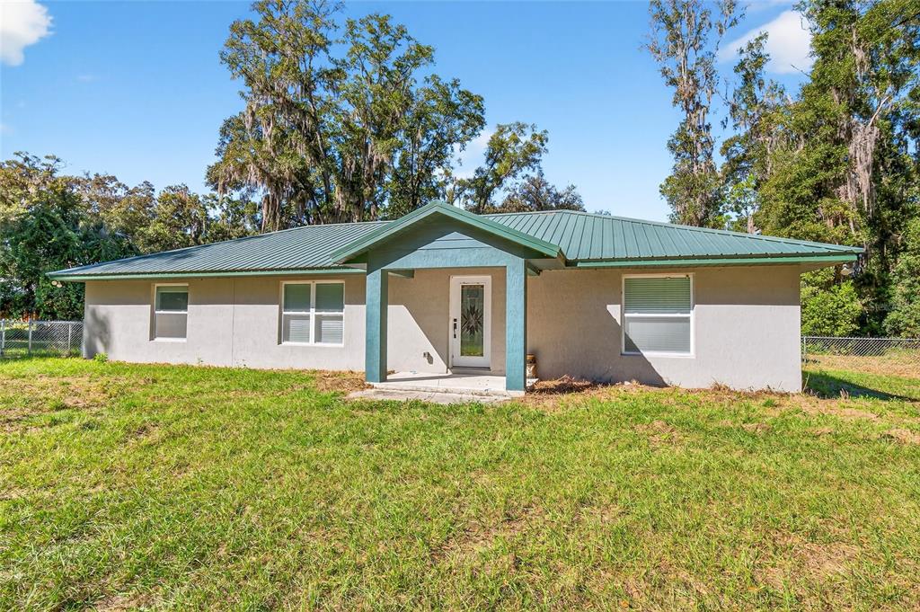 A single-story house with a green metal roof and a covered front entryway — 201 N WEST STREET, INTERLACHEN, FL