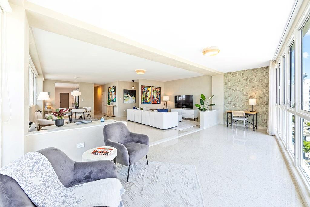 An open-concept living area with white tile floors, a sunken seating area, and large windows — 57 ASHFORD AVENUE UNIT 5, SAN JUAN, PR